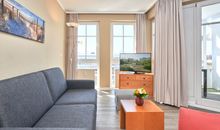 Seeblick-Balkon und Blick ins Schlafzimmer mit Boxspringbett