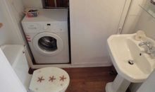 Separates WC mit Waschbecken und Waschmaschine