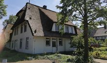 Ansicht mit Eingangstür vorn und Sichtschutz um die Terrasse rechts am Rand