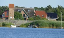 Blick vom Selliner See auf das Ferienhaus Haus am Deich (das 2. Haus mit rotem Dach und geöffnetem Fenster von vorne)