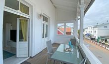 bestuhlter Balkon mit Blick ins Wohnzimmer