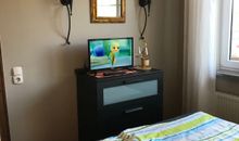 Schlafzimmer mit kleinem TV und Kommode