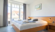 Das Schlafzimmer mit Doppelbett und Zugang zum Balkon