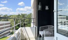 bestuhlter Balkon mit Blick ins Wohnzimmer