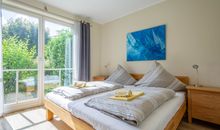 Das erste Schlafzimmer mit Doppelbett und Zugang zur West-Terrasse