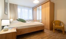 Das erste Schlafzimmer mit Doppelbett und Kleiderschrank