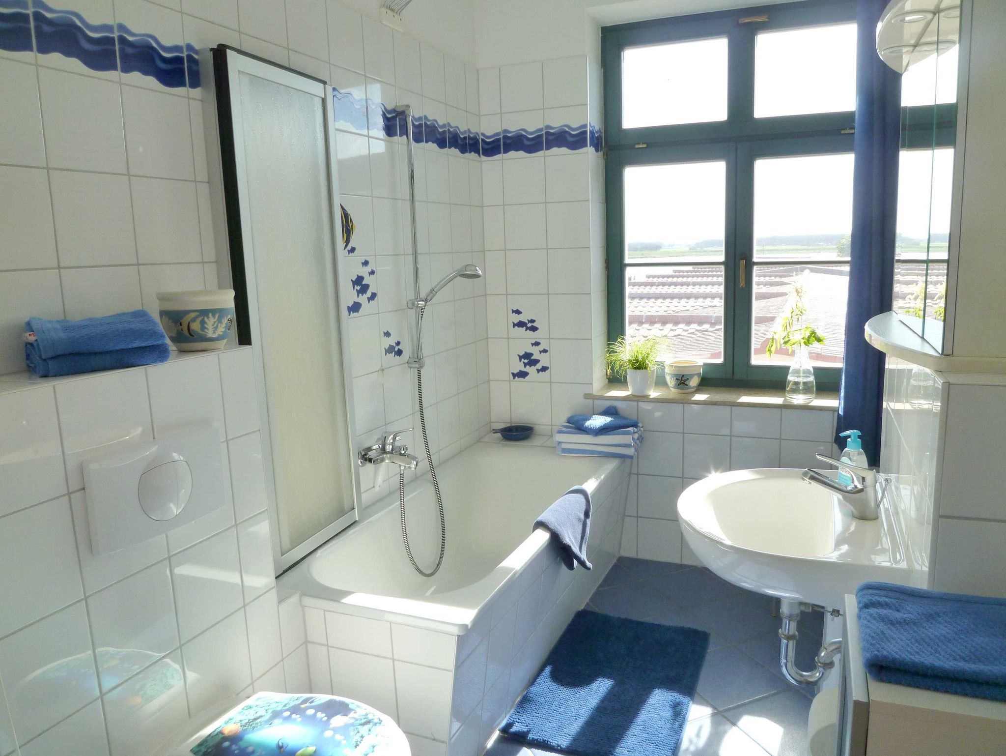 Helles Bad in maritimem Design mit Badewanne und Duschvorrichtung