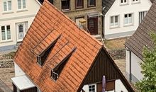 Blick vom Kirchturm auf die Rückseite des Hauses mit dem Balkon der Fewo im ersten Stock