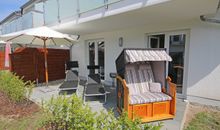 Terrasse mit Sonnenschirm und Strandkorb