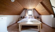 Das erste Schlafzimmer mit Doppelbett und großem Kleiderschrank