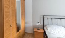 Schlafzimmer mit Nachtkommode und Kleiderschrank