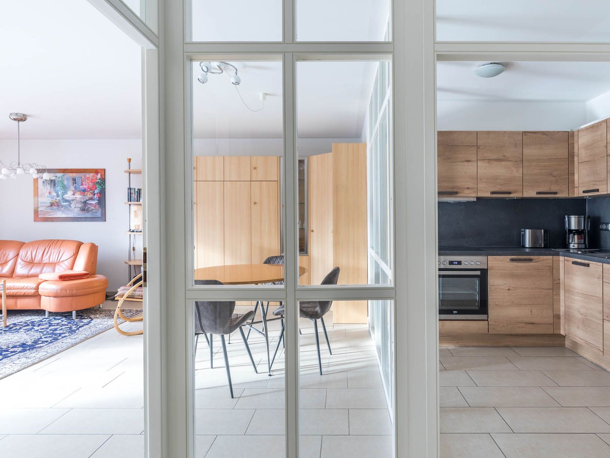 Helle Küche mit Wohnzimmer durch Glastrennwand